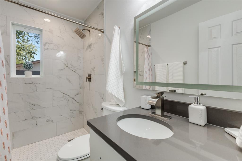 1705 Magnolia Drive Mesquite, TX 75149 - Photo 12 of 24 a bathroom with a sink toilet a mirror and shower