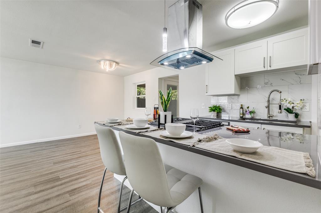 1705 Magnolia Drive Mesquite, TX 75149 - Photo 7 of 24 a kitchen with stainless steel appliances a table chairs refrigerator and cabinets