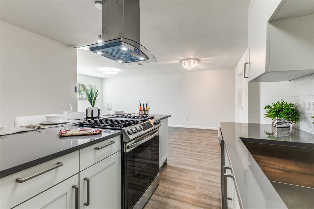 1705 Magnolia Drive Mesquite, TX 75149 - Photo 8 of 24 a kitchen with stainless steel appliances a stove and a wooden floor