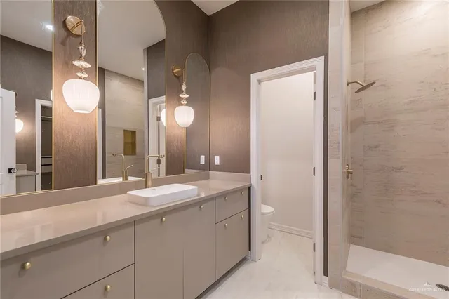 a bathroom with a shower sink and mirror