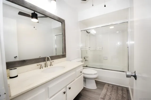 a bathroom with a double vanity sink toilet mirror and shower