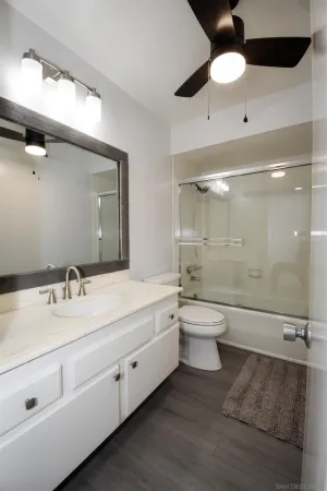 a bathroom with a double vanity sink toilet mirror and bathtub