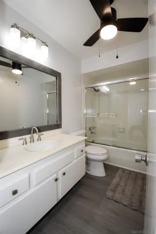 a bathroom with a double vanity sink toilet mirror and bathtub