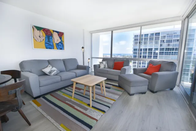 a living room with furniture a rug and a large window