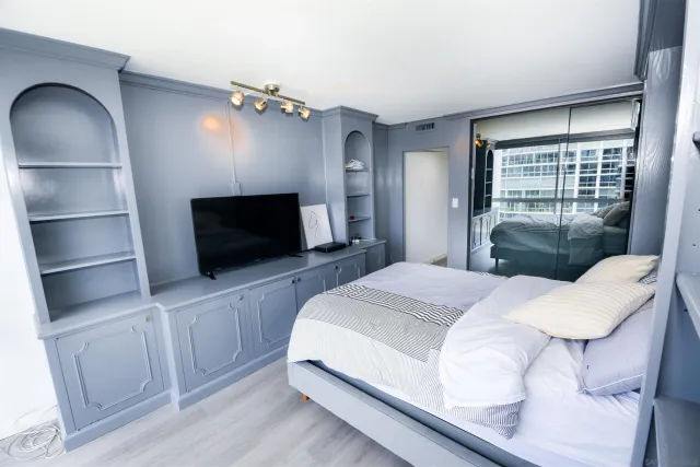 a bedroom with a bed and a television