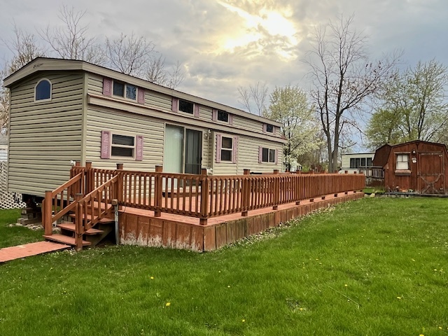 a view of a house with a yard and deck
