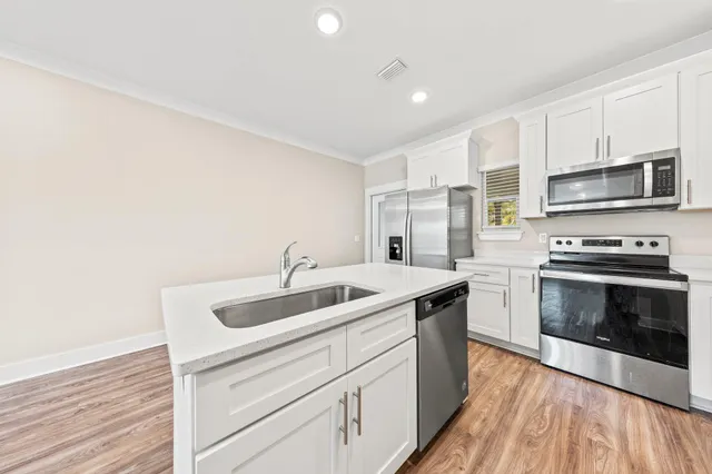 a kitchen with stainless steel appliances granite countertop a sink and a stove