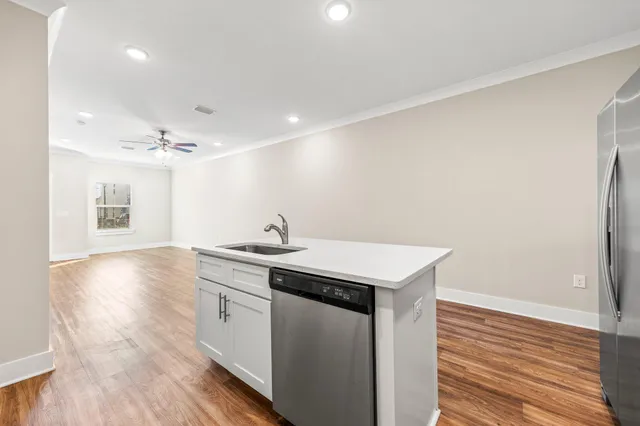 a kitchen with a sink cabinets and wooden floor