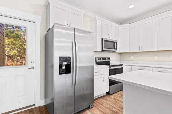 a kitchen with stainless steel appliances granite countertop a refrigerator and a stove top oven