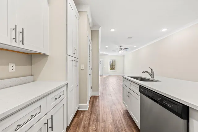 a kitchen with a sink and wooden floor