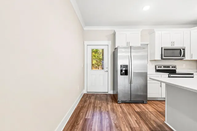 a kitchen with a refrigerator and a stove top oven