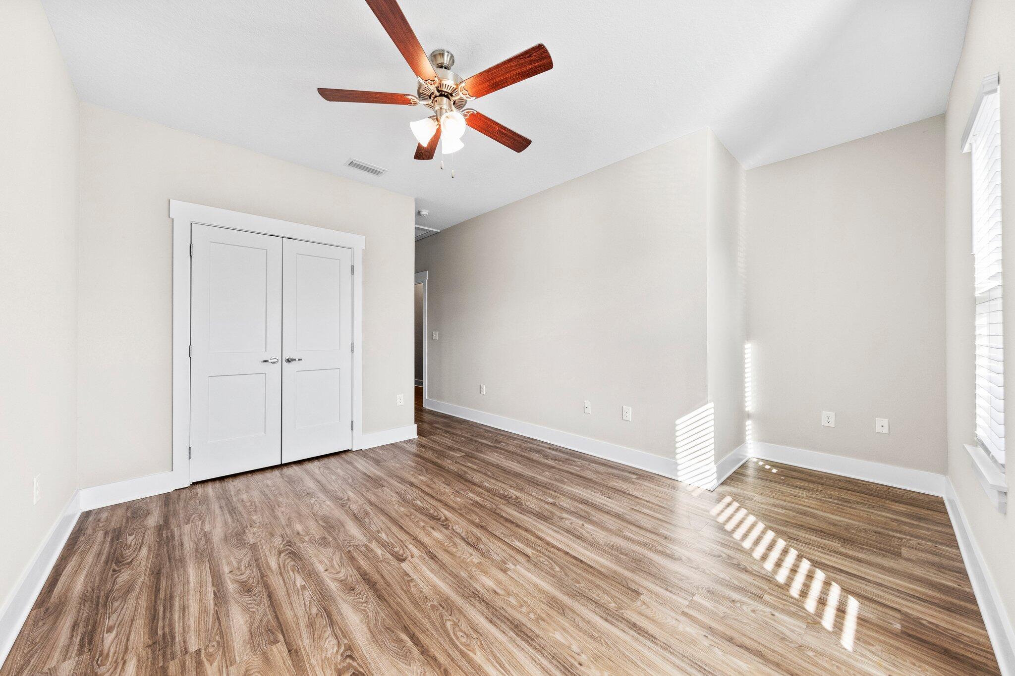 246 North Sand Palm Road Freeport, FL 32439 - Photo 19 of 36 an empty room with wooden floor and windows