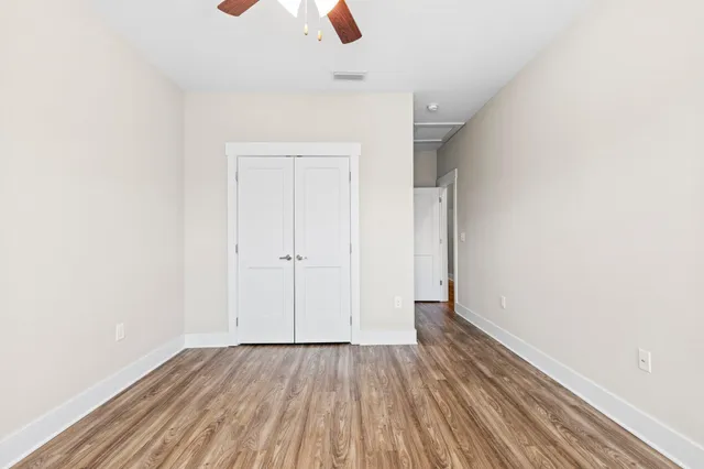 a view of an empty room with wooden floor