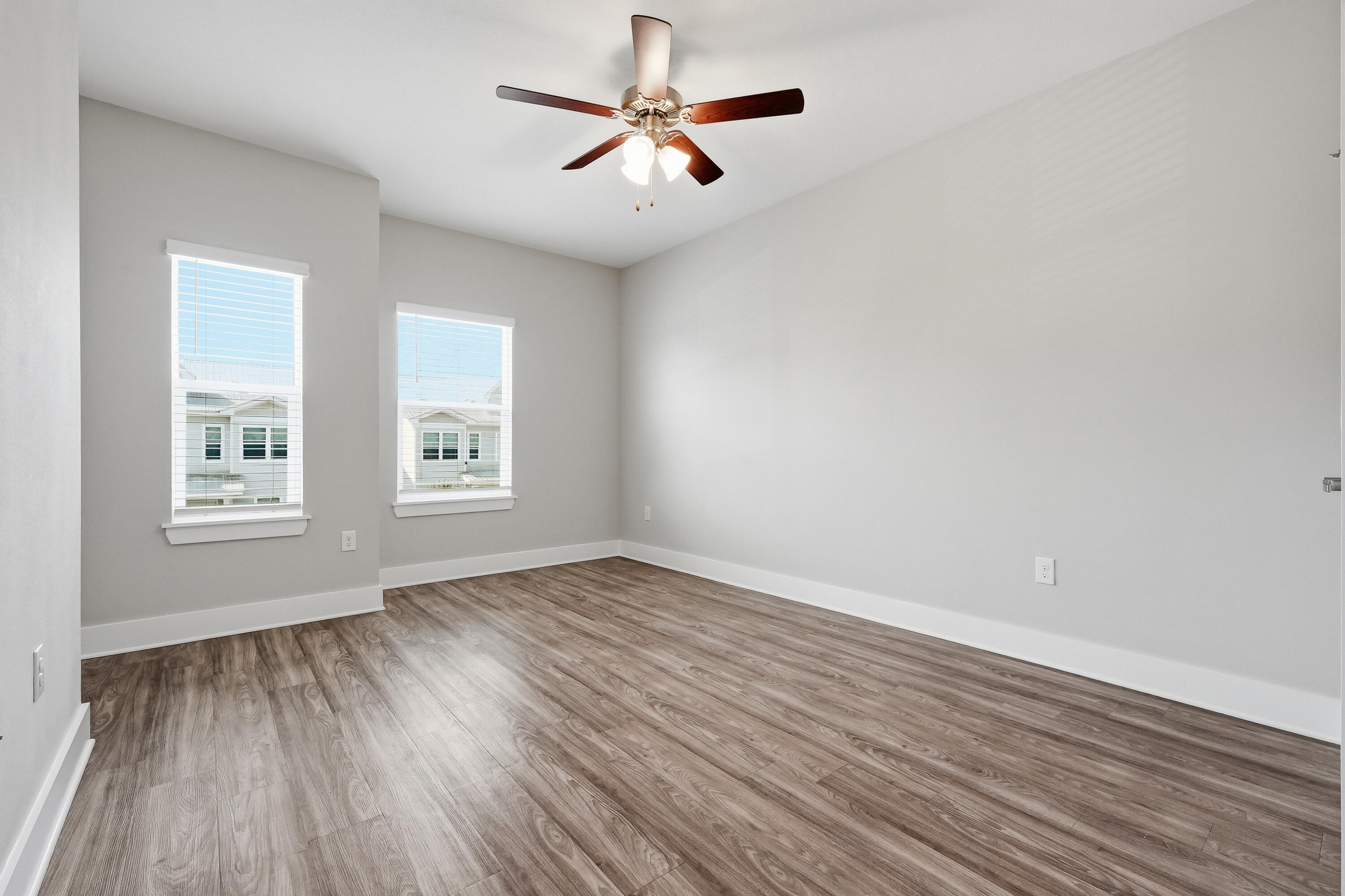 246 North Sand Palm Road Freeport, FL 32439 - Photo 22 of 42 an empty room with wooden floor ceiling fan and windows