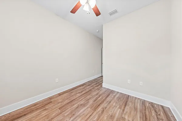 a view of a room with wooden floor and white walls