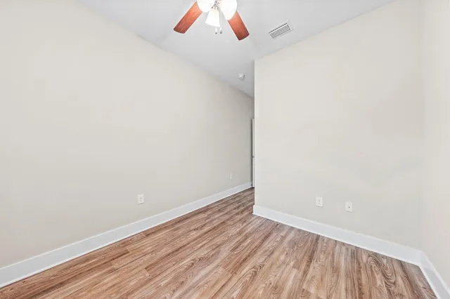a view of a room with wooden floor and white walls