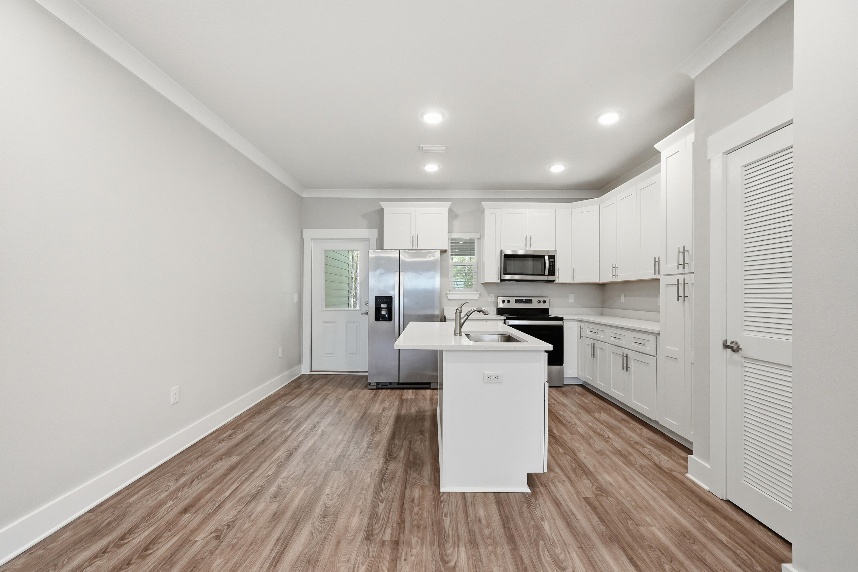 246 North Sand Palm Road Freeport, FL 32439 - Photo 5 of 42 a kitchen with a refrigerator and white cabinets