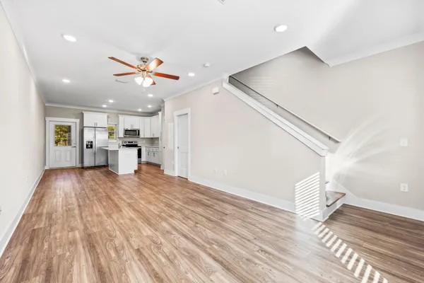a view of a living room with wooden floor and a ceiling fan