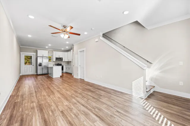 a view of a living room with wooden floor and a ceiling fan