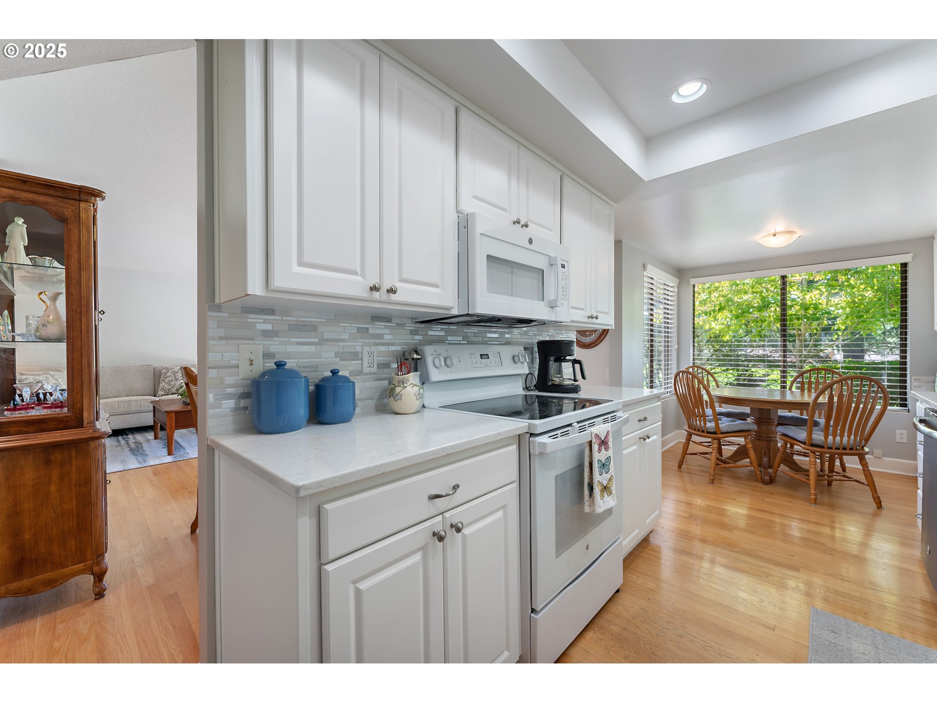 15730 Southwest Greens Way Portland, OR 97224 - Photo 14 of 42 a kitchen with stainless steel appliances granite countertop a stove a sink a refrigerator and white cabinets with wooden floor