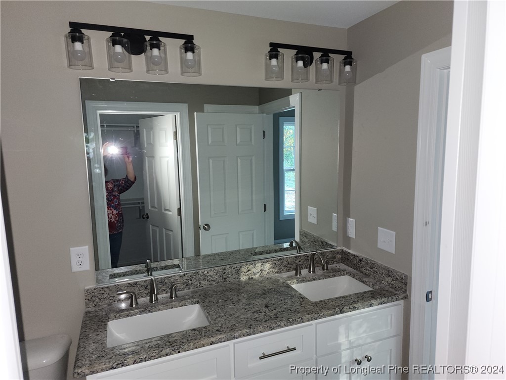 910 West Street Smithfield, NC 27577 - Photo 33 of 47 a bathroom with a granite countertop sink and a mirror