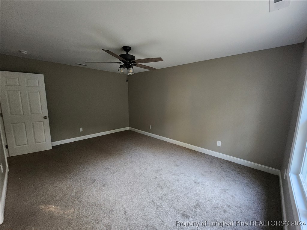 910 West Street Smithfield, NC 27577 - Photo 39 of 47 an empty room with a ceiling fan and a window