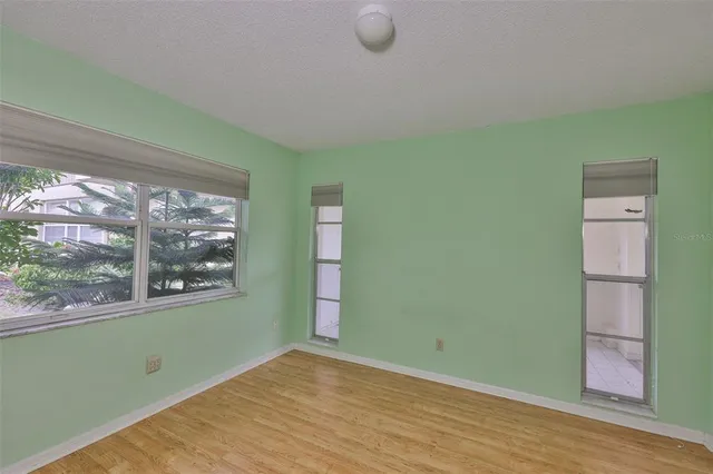 a view of empty room with wooden floor