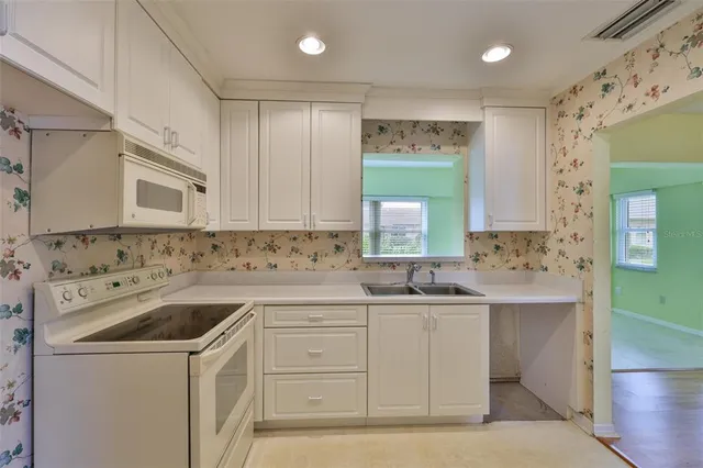 a view of a sink and dishwasher with cabinets