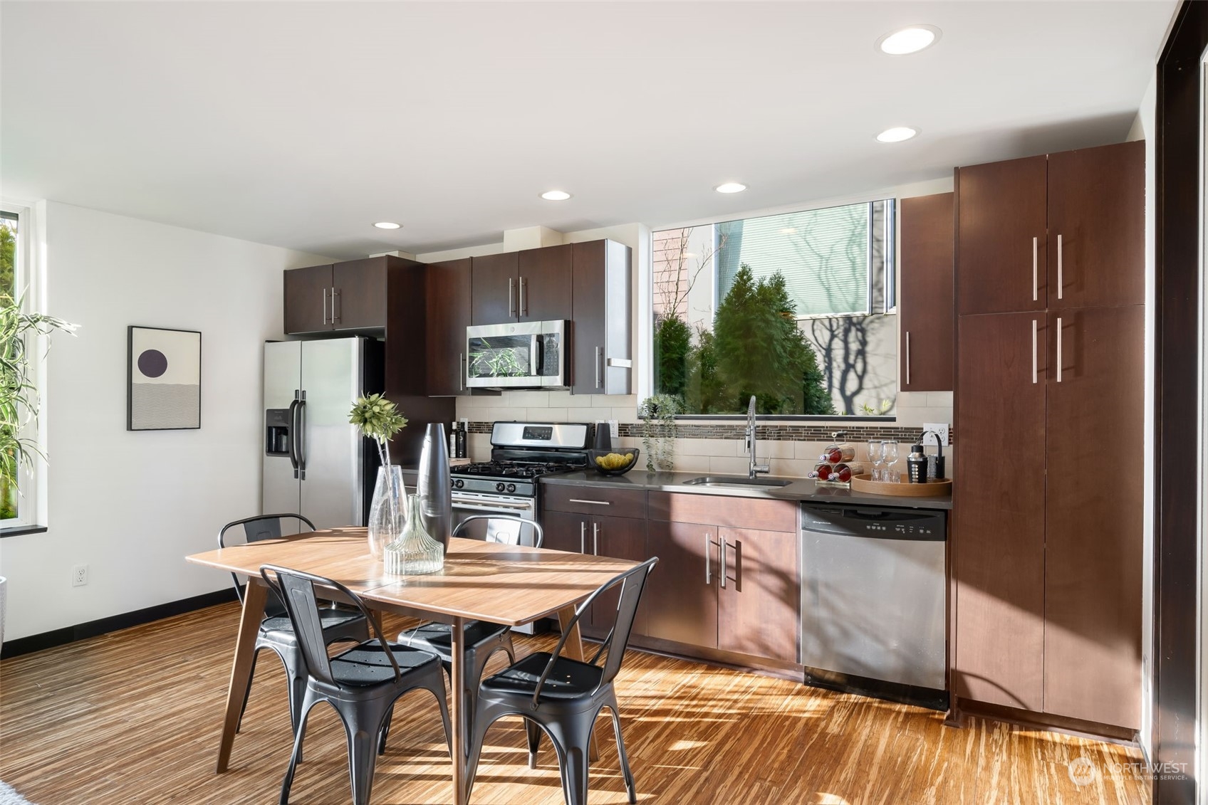 830 Northwest 53rd Street, Unit B Seattle, WA 98107 - Photo 10 of 28 a kitchen with a table chairs refrigerator and cabinets