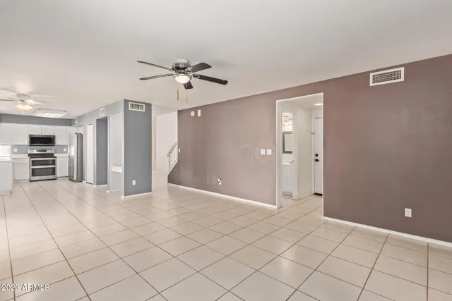 a kitchen with granite countertop a refrigerator and a stove top oven
