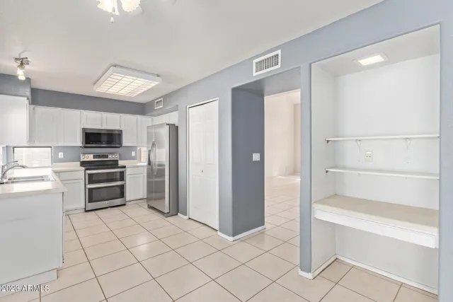 a kitchen with a sink window and refrigerator