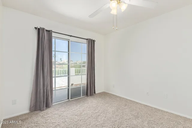 an empty room with a ceiling fan and a window