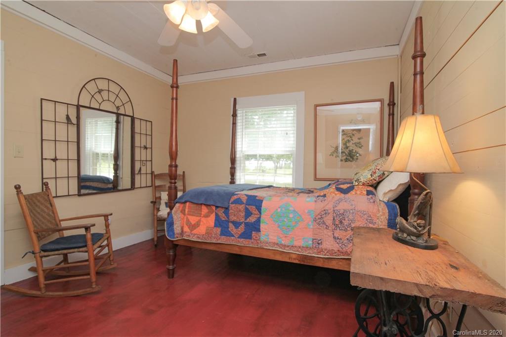 15 Big Level Road Mill Spring, NC 28756 - Photo 13 of 20 a bedroom with a bed a chair and a chandelier