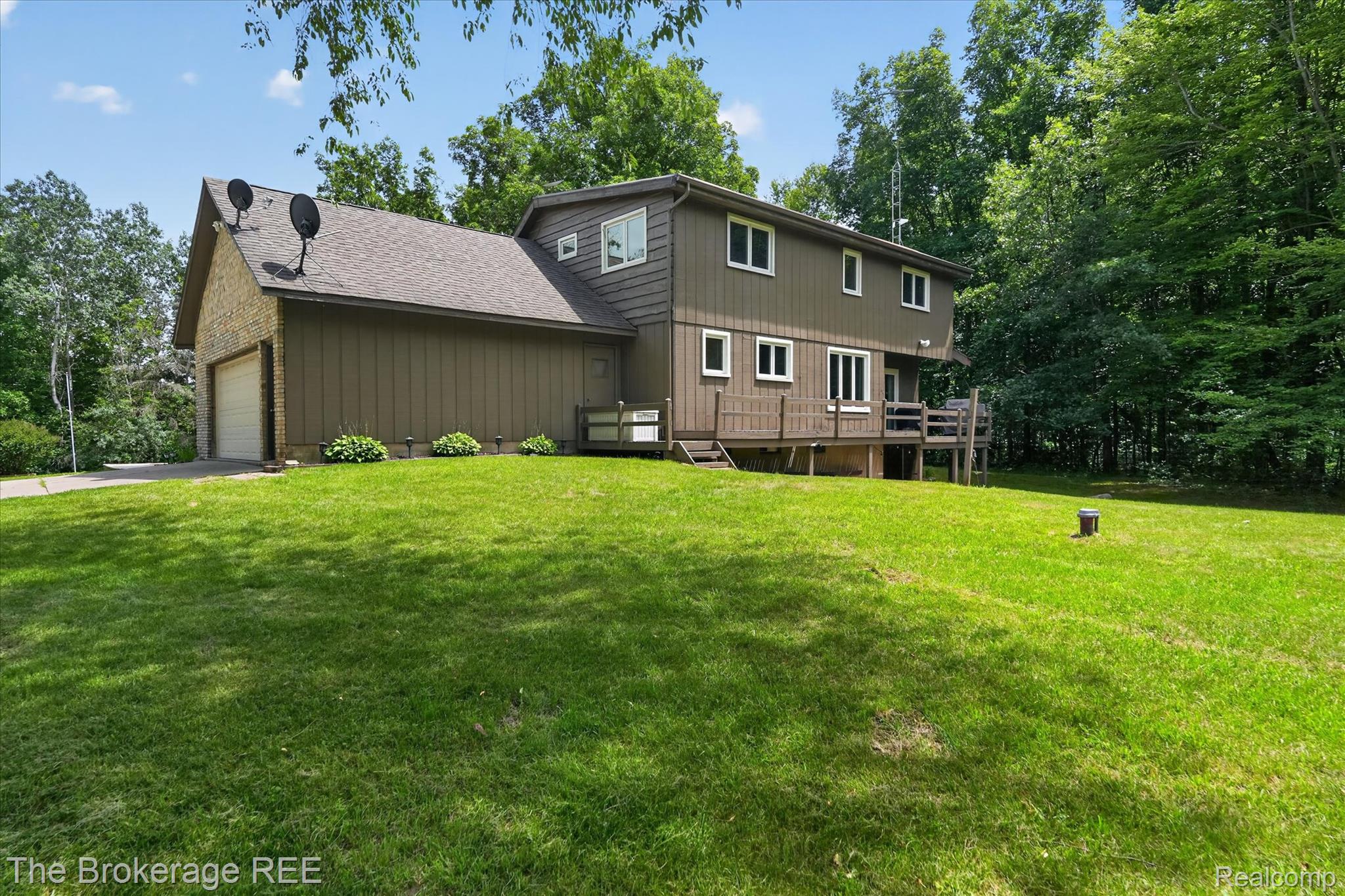 13269 North Genesee Road Clio, MI 48420 - Photo 47 of 67 Expansive green lawn surrounding a multi-level residence with a large attached garage featuring a white door