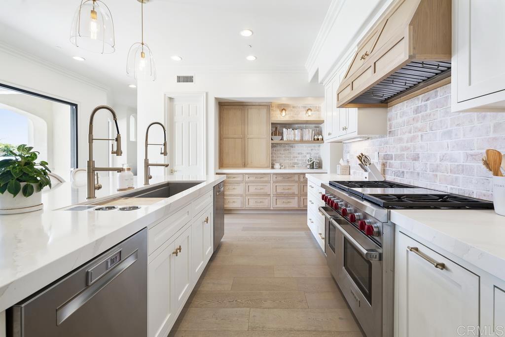 8 Corte Vizcaya San Clemente, CA 92673 - Photo 14 of 62 a large white kitchen with stainless steel appliances granite countertop a lot of counter space and wooden floors