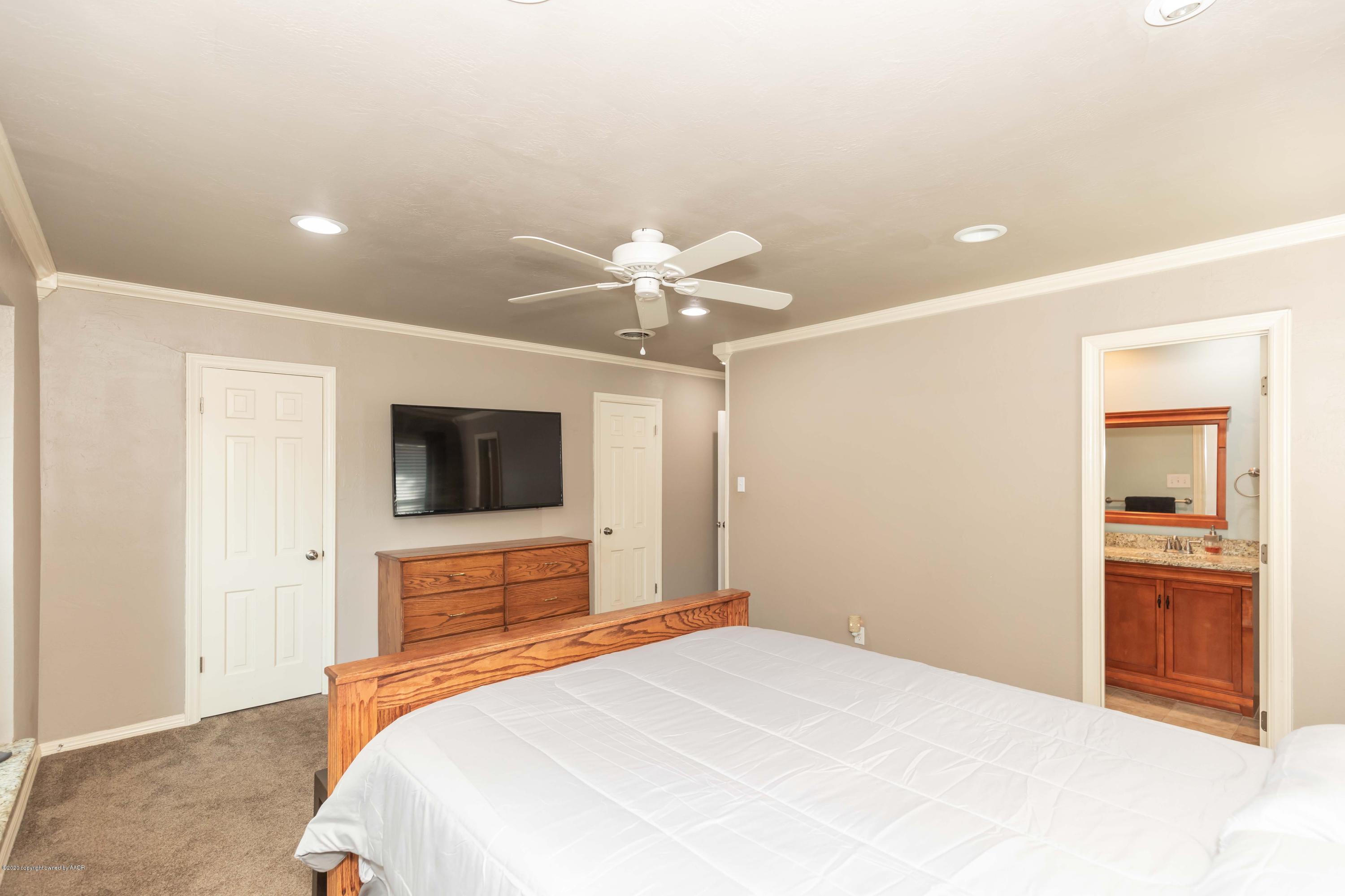 6710 Jameson Road Amarillo, TX 79106 - Photo 22 of 40 a bedroom with a bed and a flat screen tv