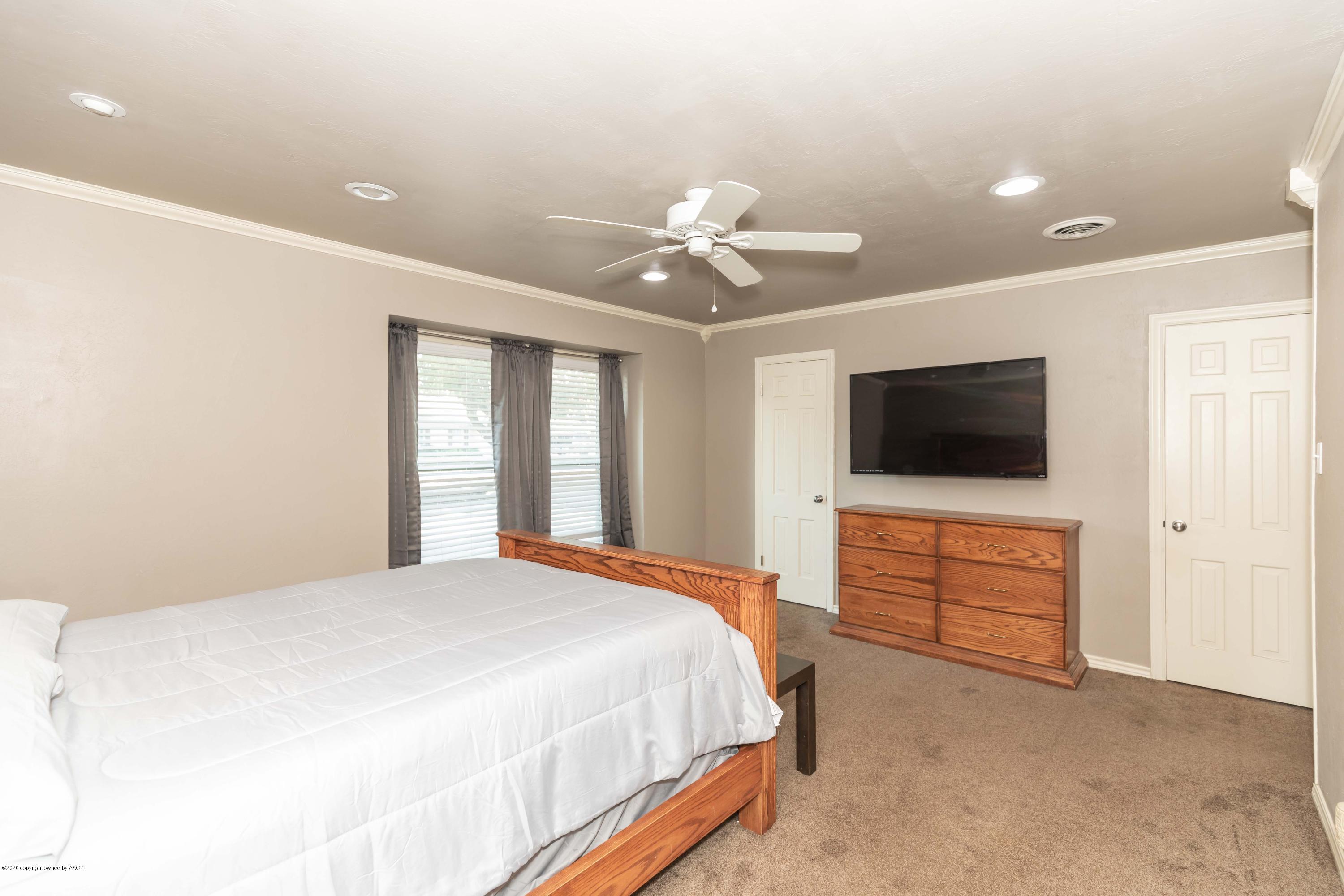 6710 Jameson Road Amarillo, TX 79106 - Photo 23 of 40 a bedroom with a bed and a flat screen tv