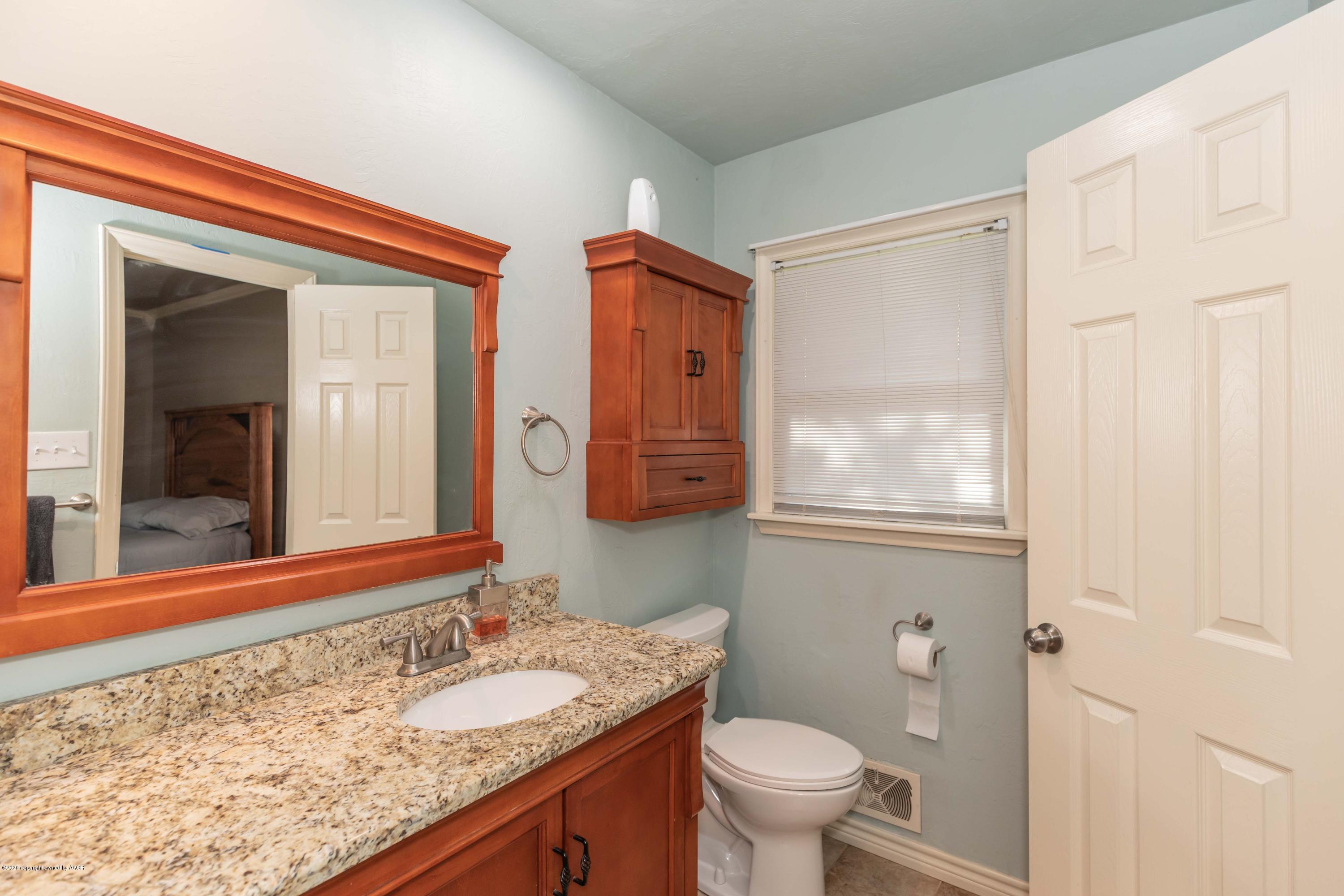 6710 Jameson Road Amarillo, TX 79106 - Photo 24 of 40 a bathroom with a granite countertop sink toilet and mirror