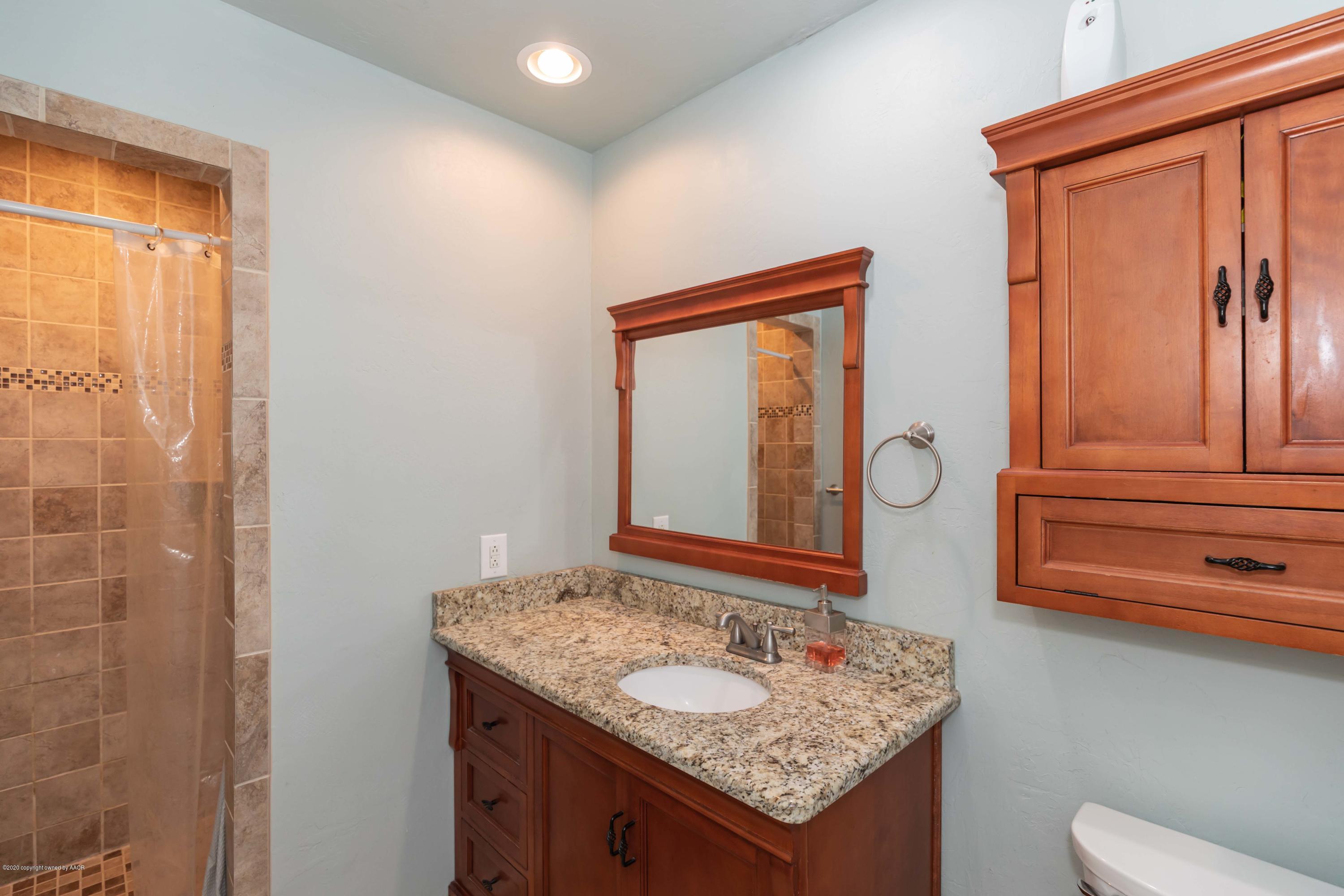 6710 Jameson Road Amarillo, TX 79106 - Photo 25 of 40 a bathroom with a granite countertop sink and a mirror