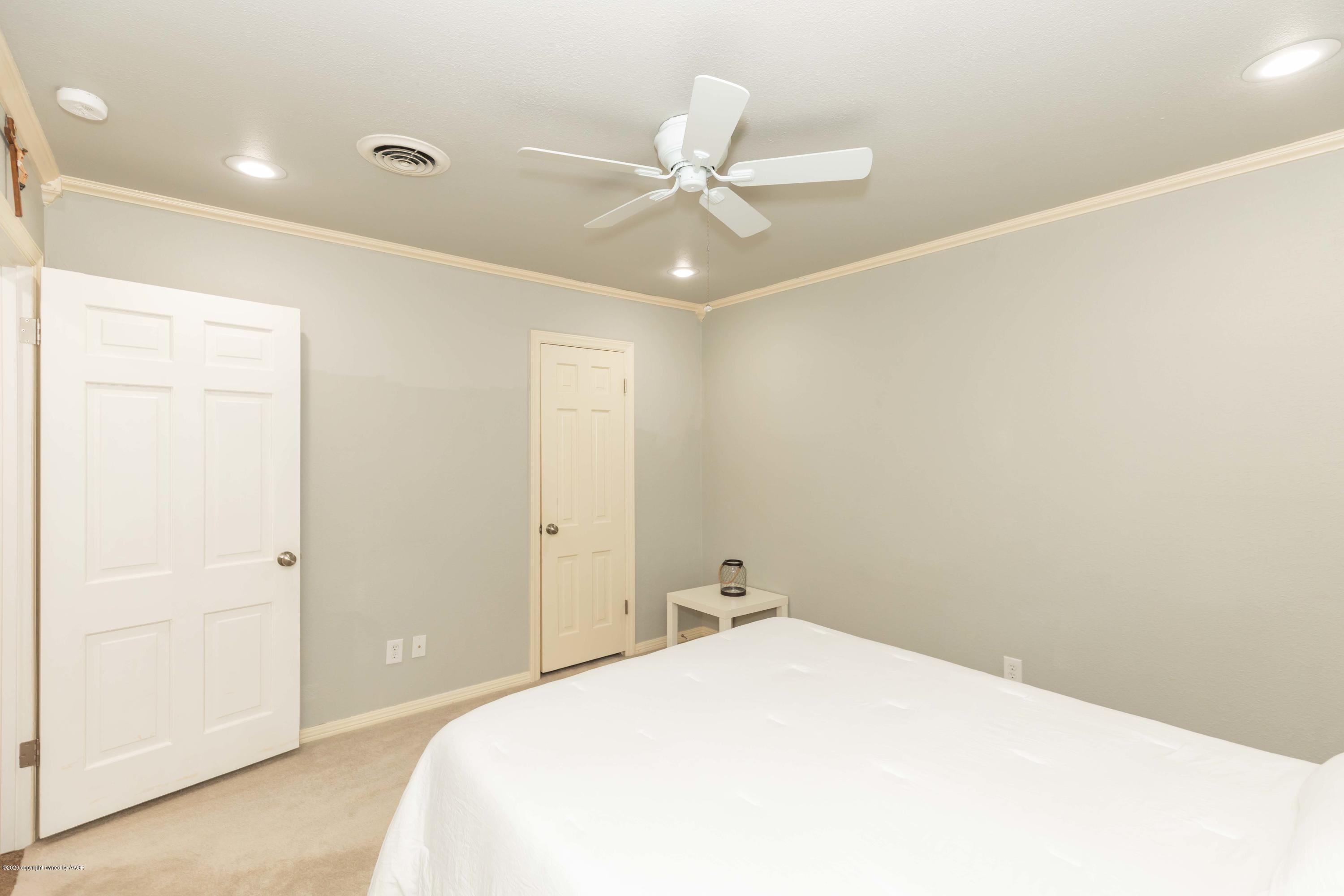 6710 Jameson Road Amarillo, TX 79106 - Photo 31 of 40 a bedroom with a bed and a chandelier
