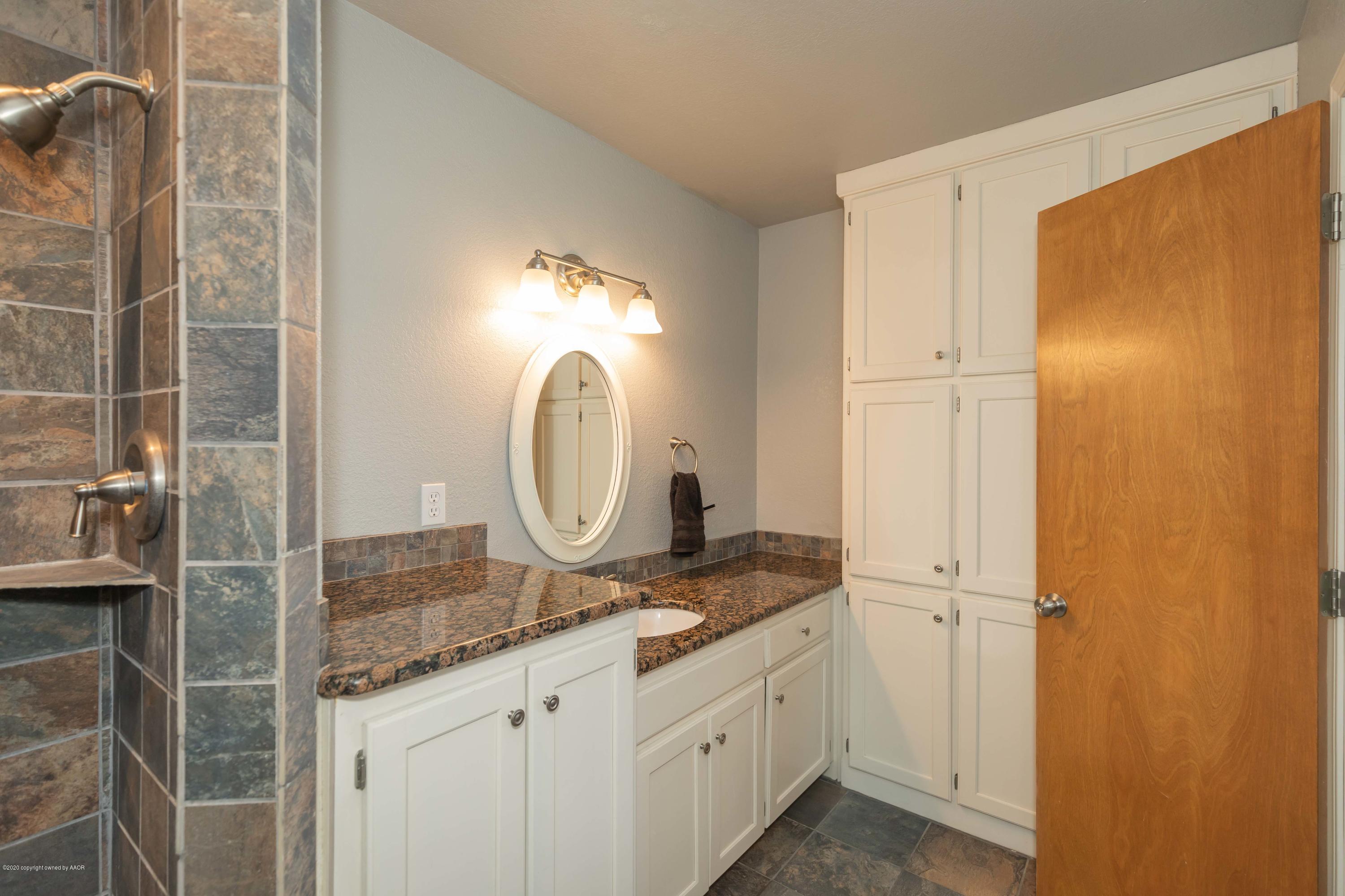 6710 Jameson Road Amarillo, TX 79106 - Photo 33 of 40 a bathroom with a granite countertop sink and a mirror