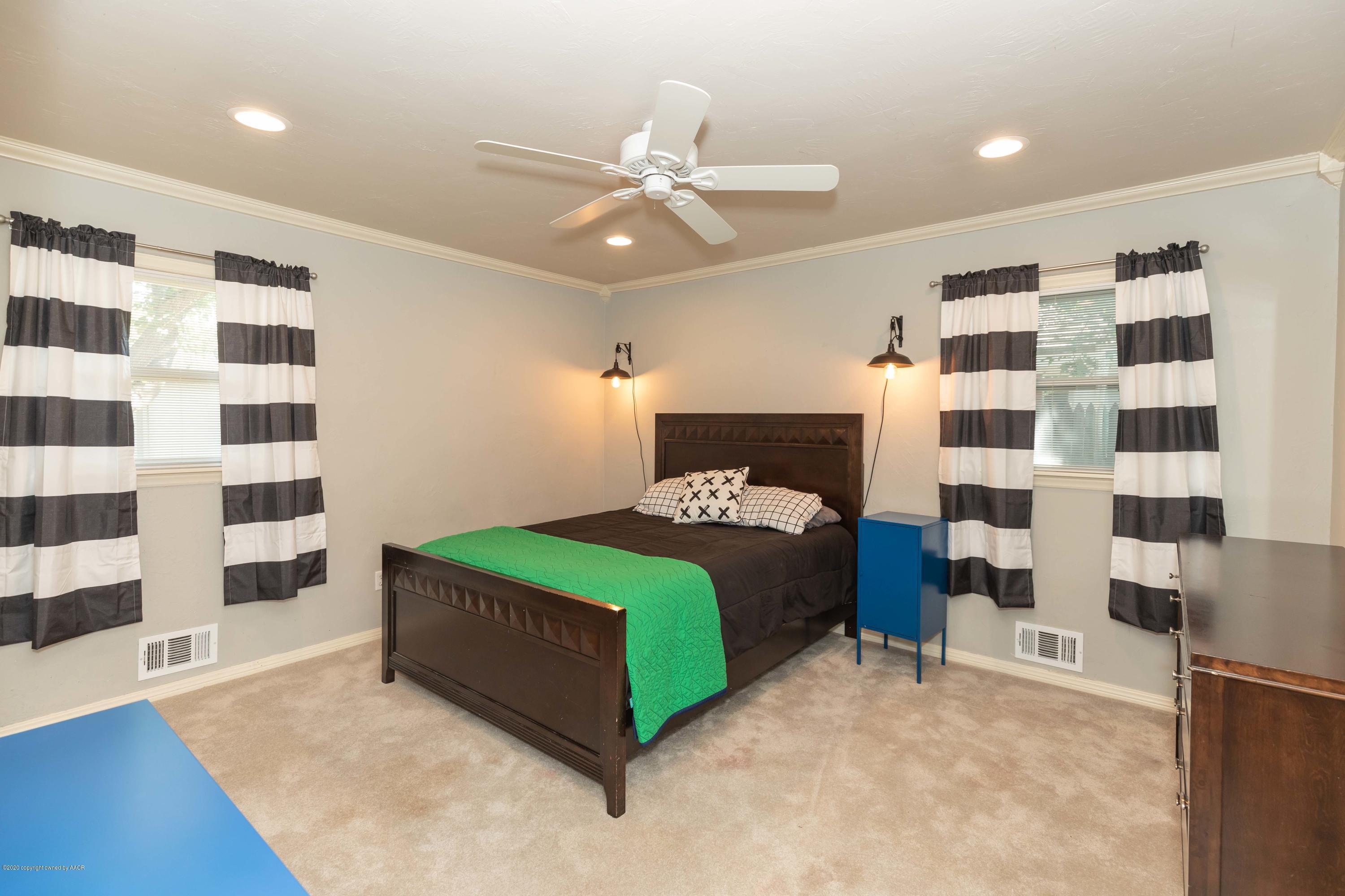 6710 Jameson Road Amarillo, TX 79106 - Photo 36 of 40 a bedroom with a bed and a black white checkered floor