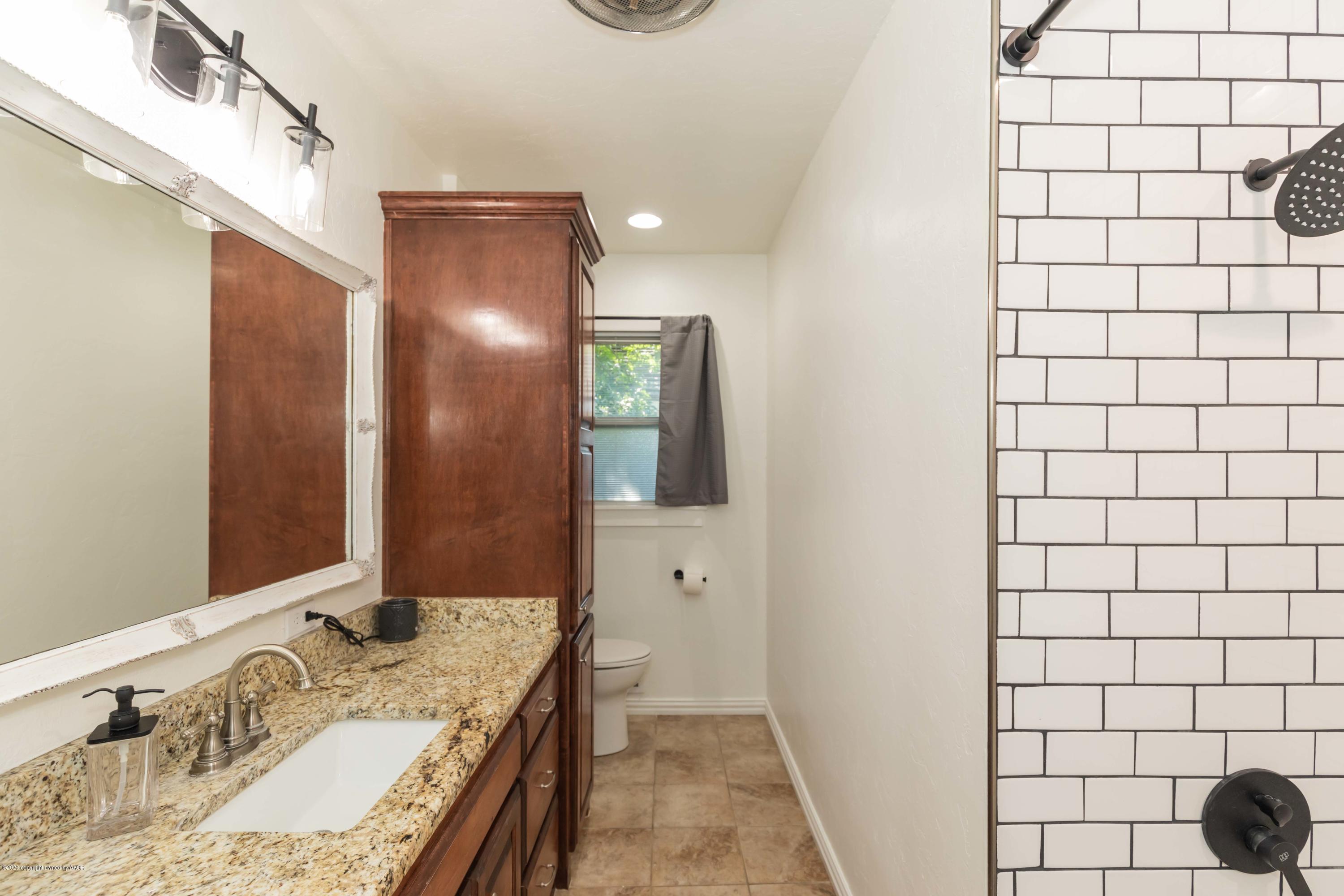 6710 Jameson Road Amarillo, TX 79106 - Photo 37 of 40 a bathroom with a granite countertop sink and a mirror