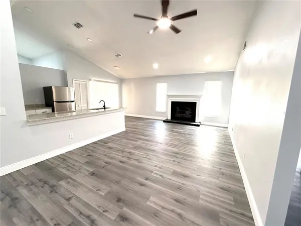 a view of a kitchen with wooden floor and a ceiling fan