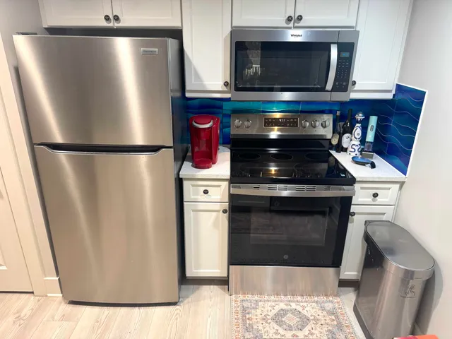 a kitchen with stainless steel appliances granite countertop a stove microwave and refrigerator