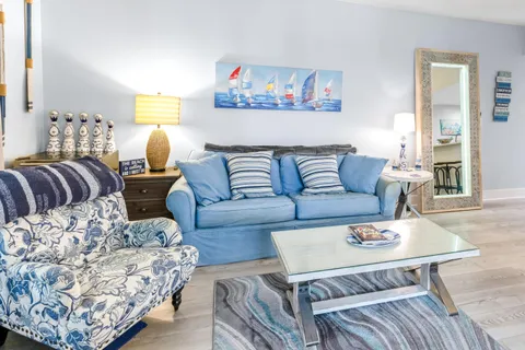 a living room with furniture a flat screen tv and a floor to ceiling window