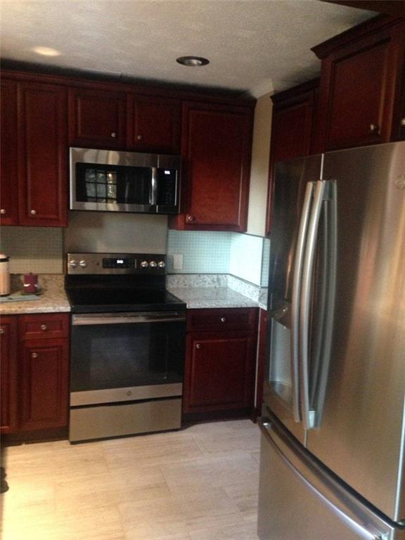 4470 East Fairview Road Southwest Stockbridge, GA 30281 - Photo 6 of 13 a kitchen with stainless steel appliances granite countertop a refrigerator and a stove top oven