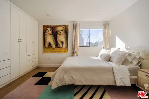 a bedroom with a bed and a painting on the wall