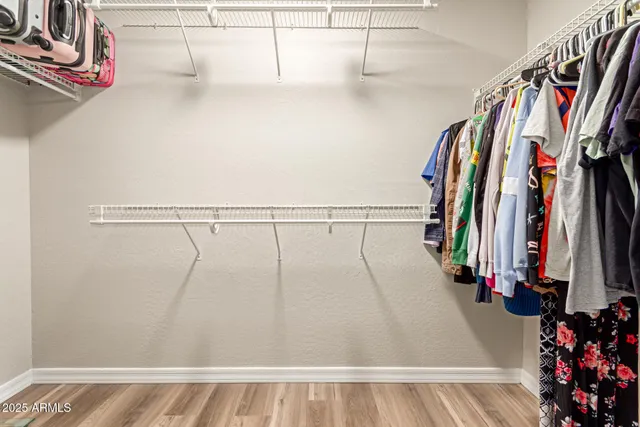 a view of walk in closet with clothes and shoes