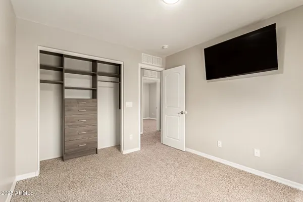 a view of an empty room with tv and a window